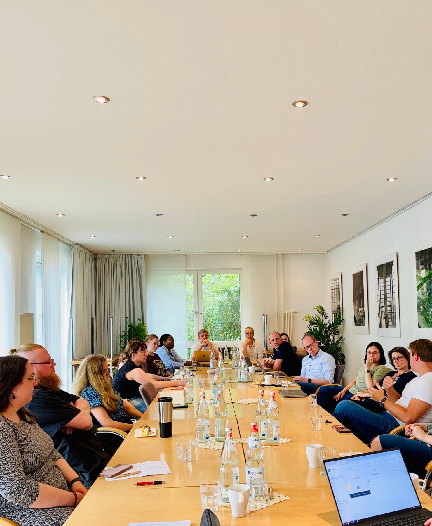 /new/Members of the UDE Aurora Community sit at a long table to meet, talk, and exchange ideas